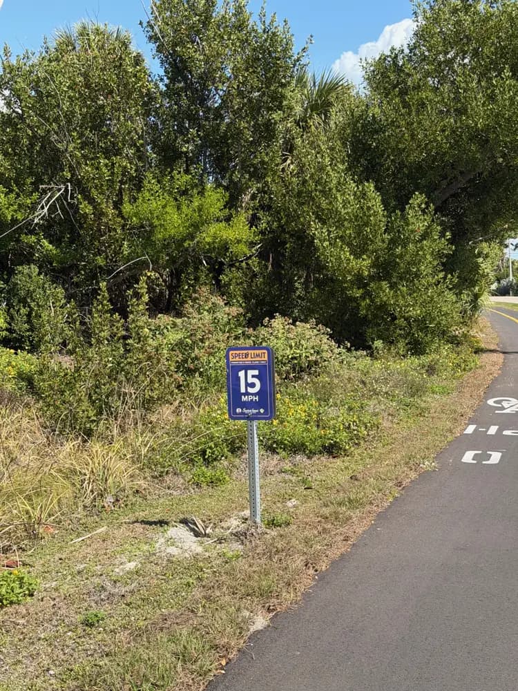 Sanibel Island shared-use bike path with speed limit sign and tropical palms